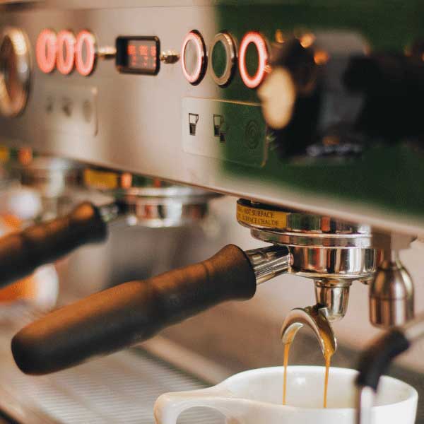Cafetera La Marzocco máquina espresso para blog CafeStore, extracción de café en taza blanca