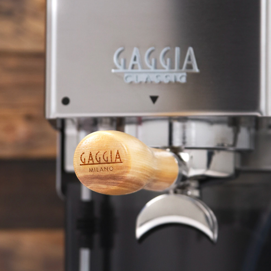 Portafiltro 58mm mango de madera para Gaggia posicionada en la cafetera mostrando su logo en el dorso del mango