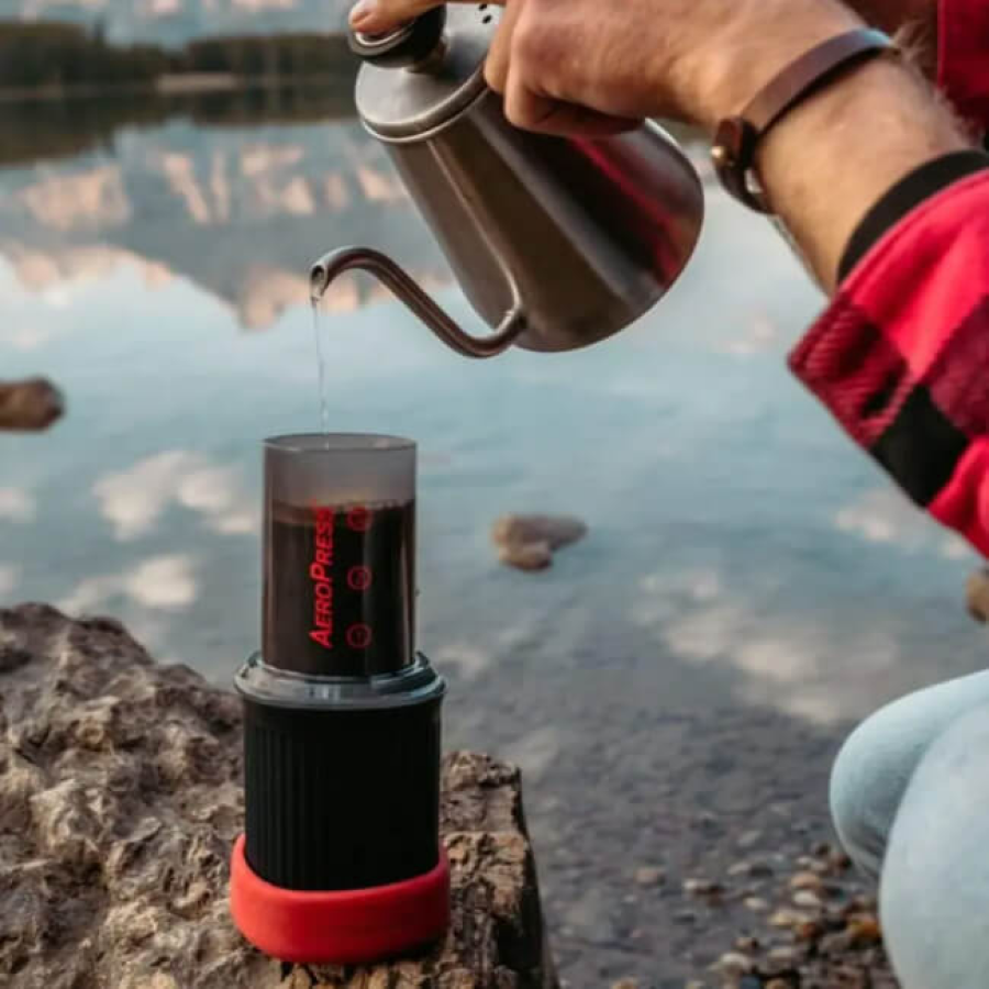 Extracción de café con Aeropress Go método Brewing, uso de tetera cuello cisne en ambiente al lado de un lago
